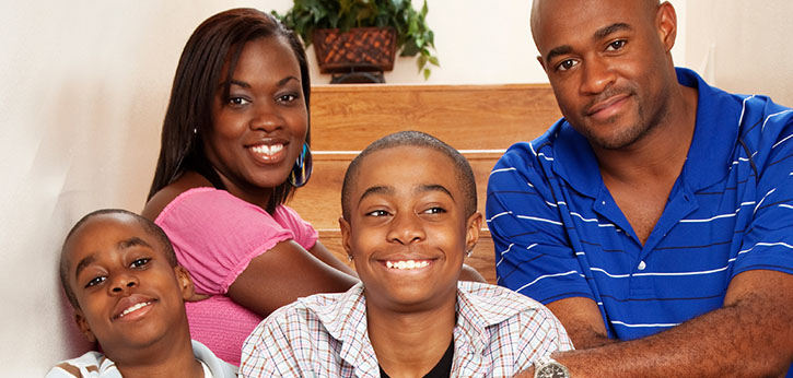 An African American family with a mother, father, and two school-age sons.