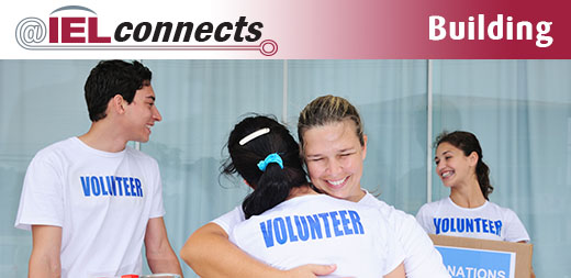 A group of young people in "volunteer" t-shirts participate in a service learning activity.