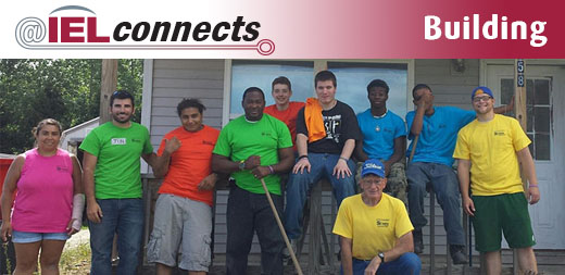 A group of youth, mentors, and staff from Peckham, the Right Turn site in Lansing, Michigan pose for a group photo during a restorative justice community service project winterizing homes for the elderly.