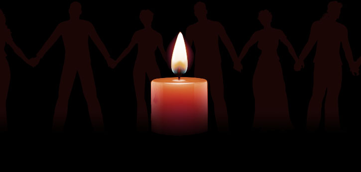 A single candle burning against a black background with shadowed silhouettes of people holding hands