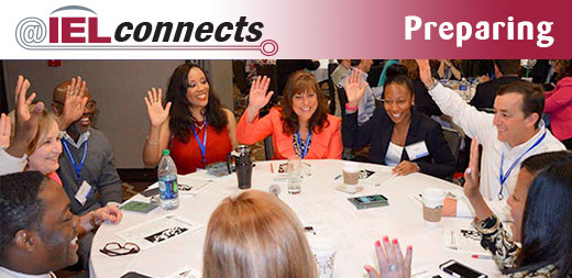 @IELconnects: Preparing: Image (a group of Education Policy Fellowship Program fellows sit in active discussion around a table, raising their hands to vote.