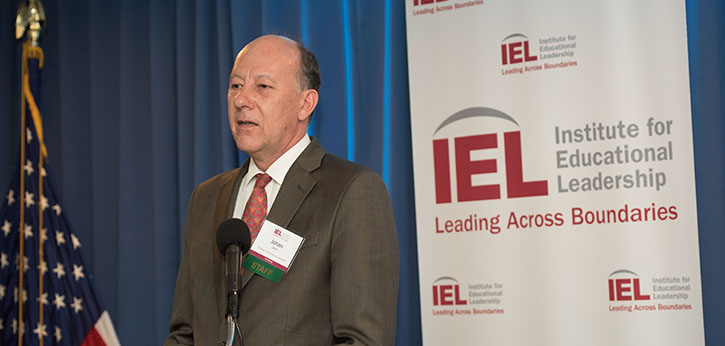 IEL President Johan E. Uvin speaks at a podium in front of an IEL logo.