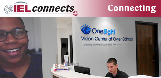 A young man sits at a reception desk at the One Sight Vision Center at Oyler School.