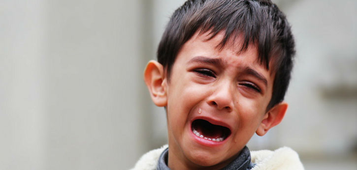 A young immigrant boy cries.