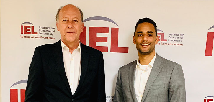 IEL President Johan E. Uvin and 2019 Meade Fellow Stefan Lallinger pose for a photo in front of a banner with the IEL logo.