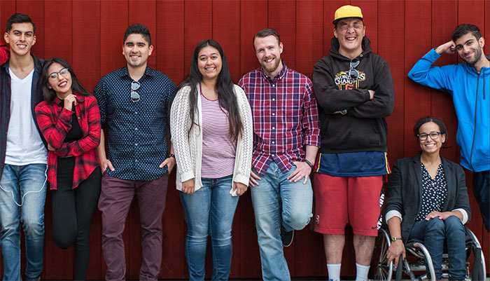 Group of high school students lean against a wall.