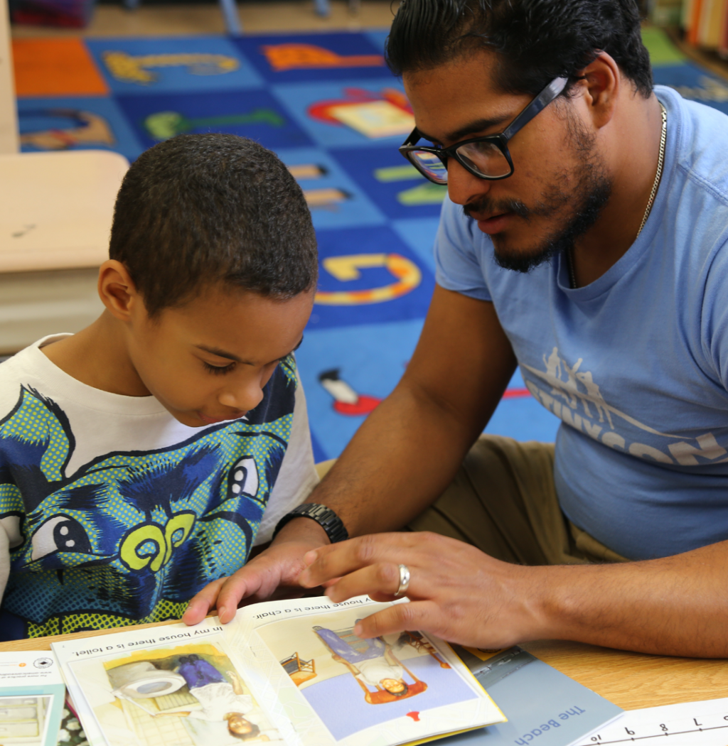 Teacher and student read a book together